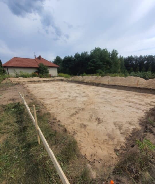 Podbudowa pod fundamenty domu, teren przygotowany pod budowę, wykopaliska, zagospodarowanie działki na budowę domu, budowa fundamentów, prace ziemne.